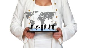 Business woman holding a pad with world map and business people connecting through online sales strategies for movers.
