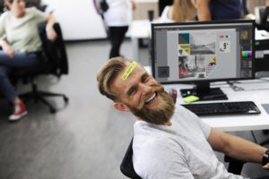 Guy sitting in office, laughing.
