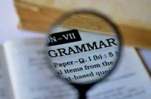 a magnifier showing the word GRAMMAR in a dictionary.