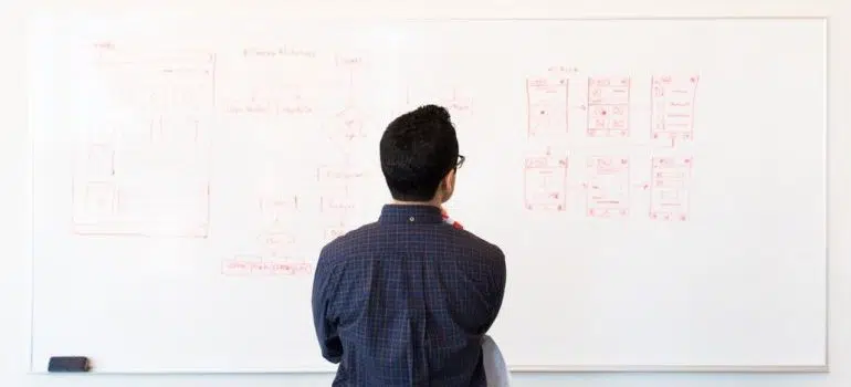 Man standing in front of white board with web development plan