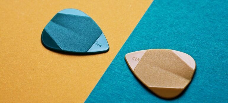 A pair of guitar picks on backgrounds of contrasting colors.