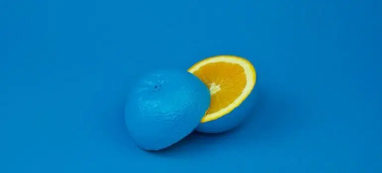 A blue orange sliced in half on a blue background.
