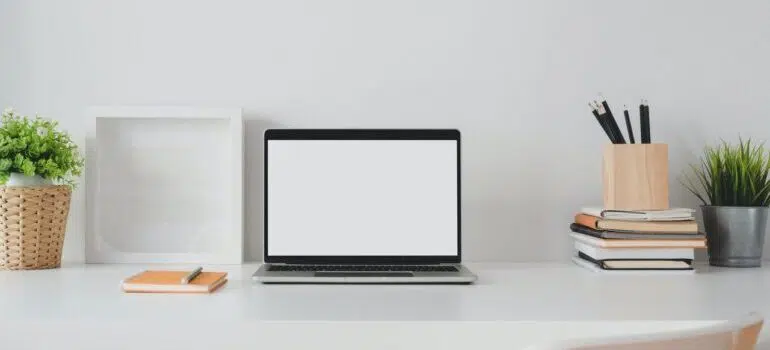 Image of laptop with white screen, in a minimalist room.
