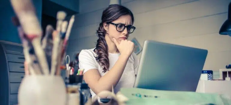 Woman looking at her laptop, worried.