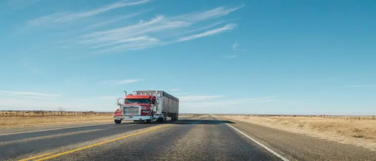 A truck going down a desert highway.