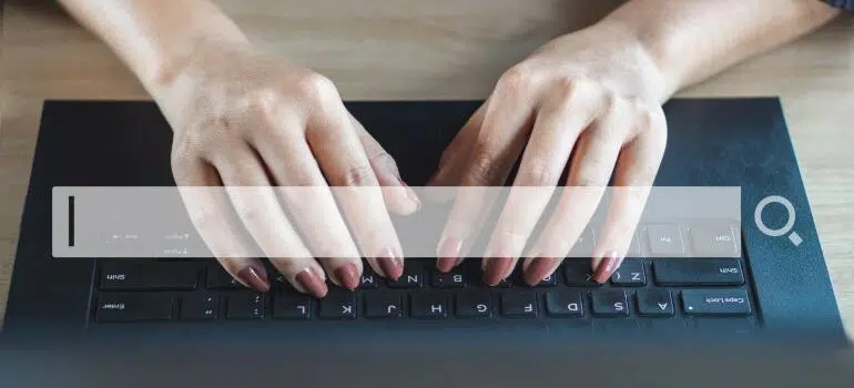 Search bar with keyboard and a person typing in the background.
