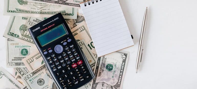 Calculator and paper used to set a marketing budget for a small business.
