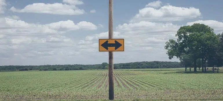 road sign with arrows pointing in different directions.