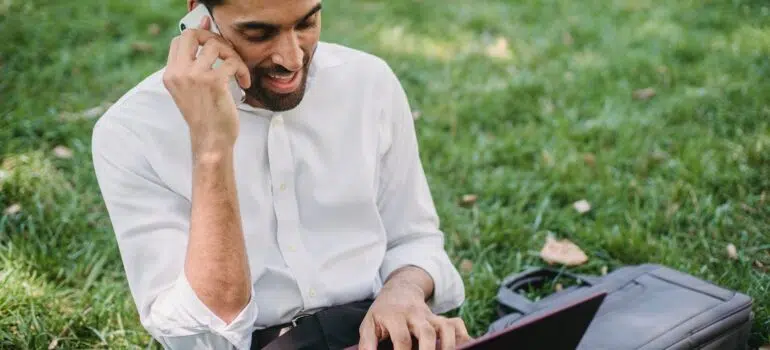 a man using a phone and a laptop