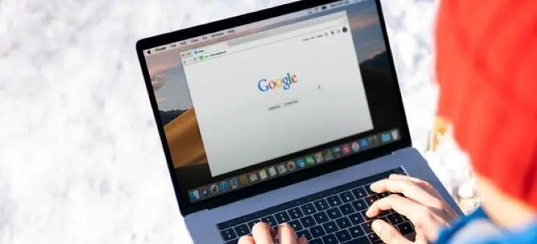 A person with a laptop in their lap about to do a Google search