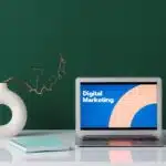 A laptop with a visual saying ''digital marketing'' siting on top of a table.