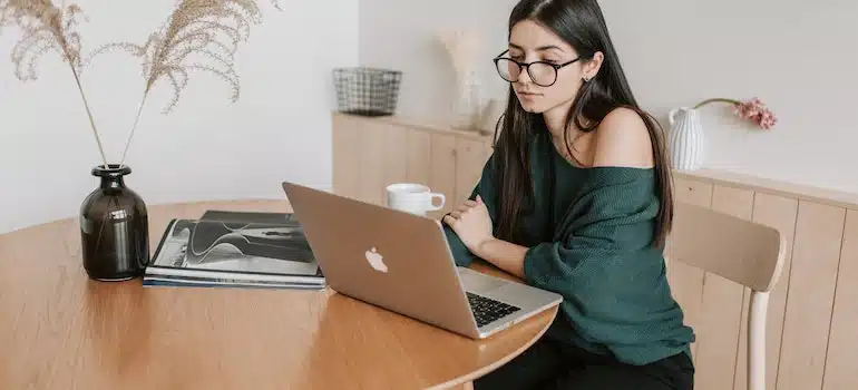 A woman sitting and looking at the laptop
