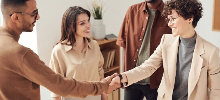 People shaking hands after discussing financial benefits of having a moving blog