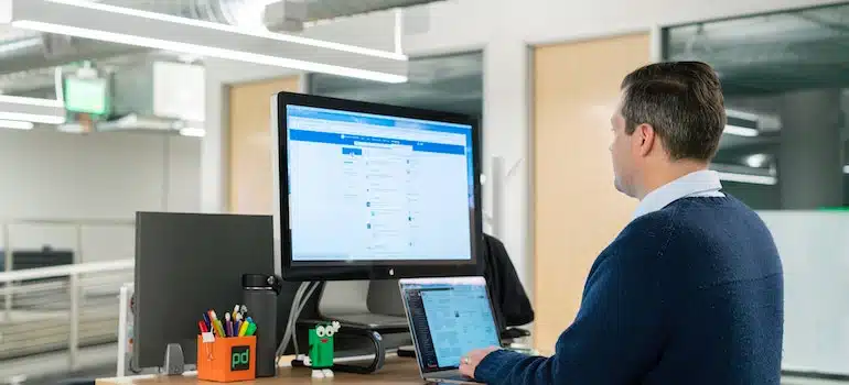 A person using a laptop and a computer to read LinkedIn guide for moving companies