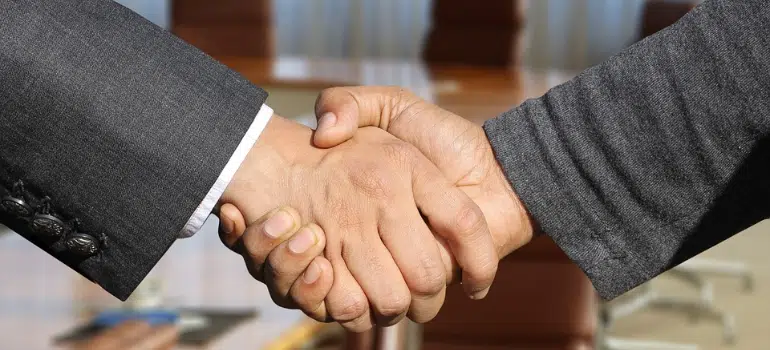 A close-up of two people in business suits shaking hands.