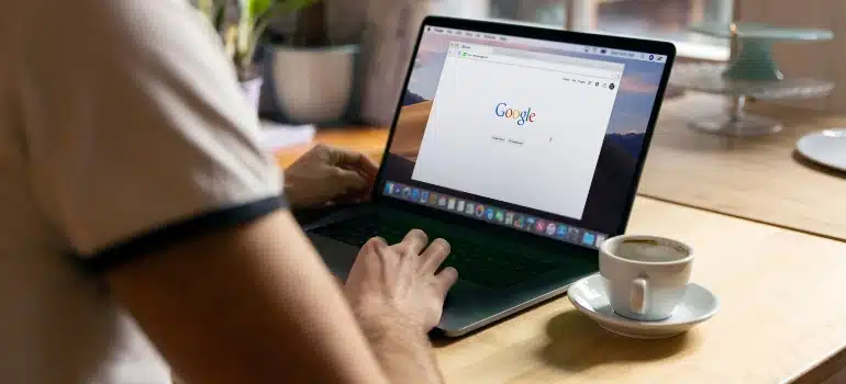 Person sitting at a desk and using a laptop to Google something