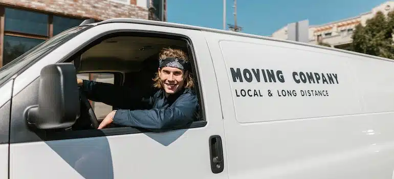 movers sitting in a moving truck and smiling