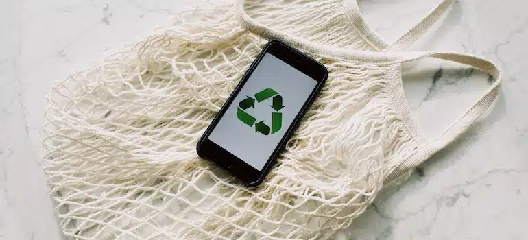 mobile phone with green recycling sign on a mash bag