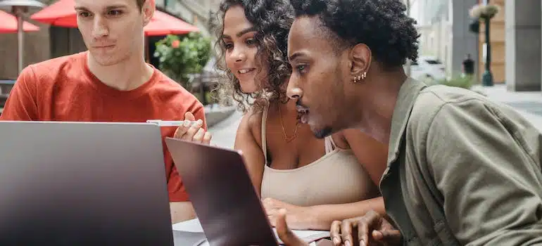 Three young people reading about marketing strategies for moving companies