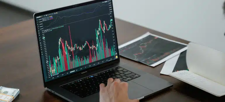 A person analyzing financial charts on a laptop screen