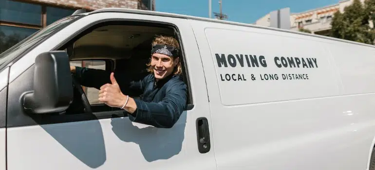 A man driving a moving company van