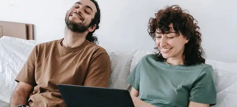 A couple using a laptop to look for companies that offer long distance moving services