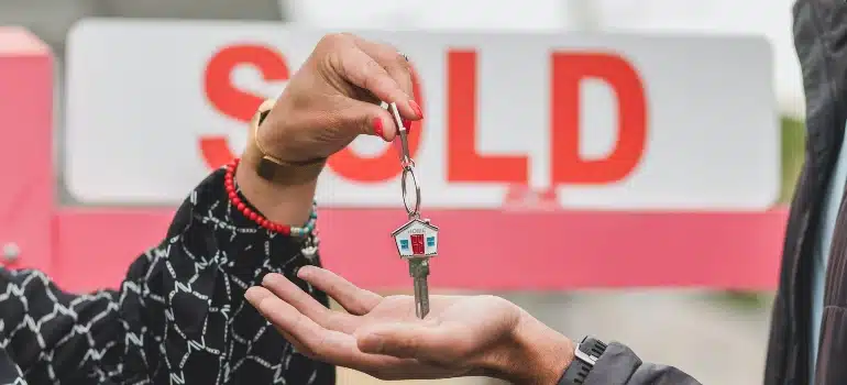 Person handing over keys after selling a home 