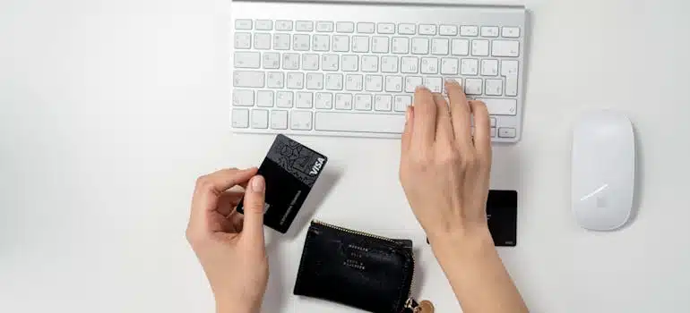 a close-up of hands holding a credit card for online purchase