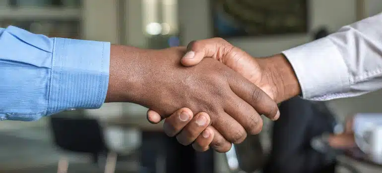 Two individuals shaking hands, symbolizing the start of a partnership to establish new referral partners for a moving company.