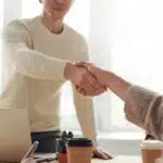 A person shaking someone's hand in the office.