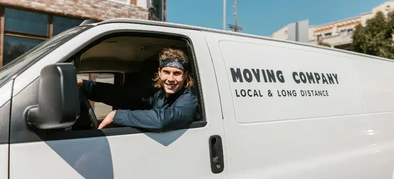 A man in a white moving van providing service on how to win more repeat business
